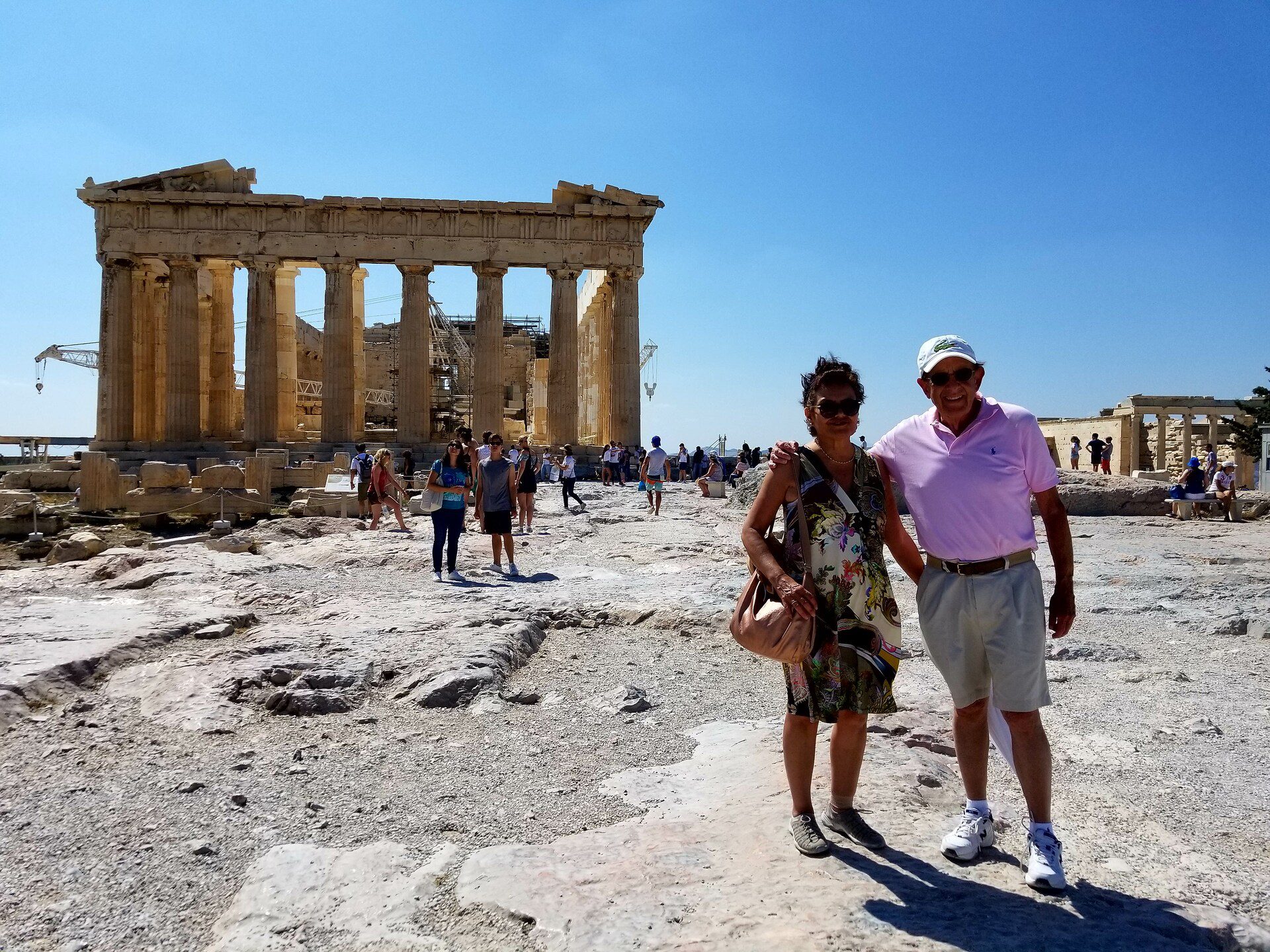 a couple standing in front of the Acropolis