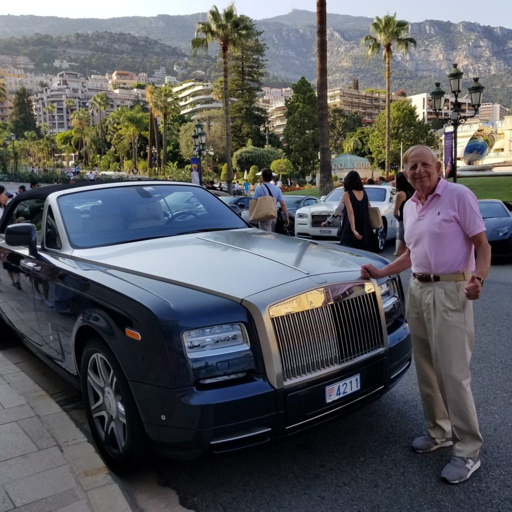 Man standing in front of a fancy black car