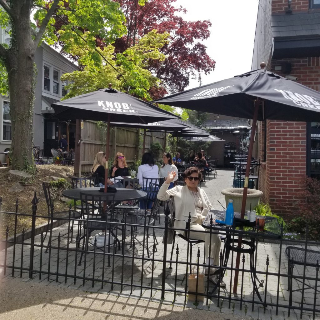 Woman enjoying a meal in an outdoor patio at 86 West, Doylestown, PA.